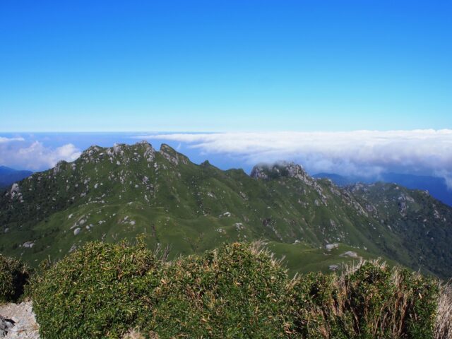 雲海の上に浮かぶ永田岳と、その向こうの海